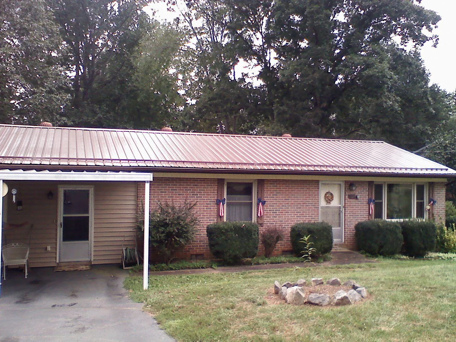 Bronze metal roof and carport on a brick ranch home — Roof Repair work by our crew in Preemption