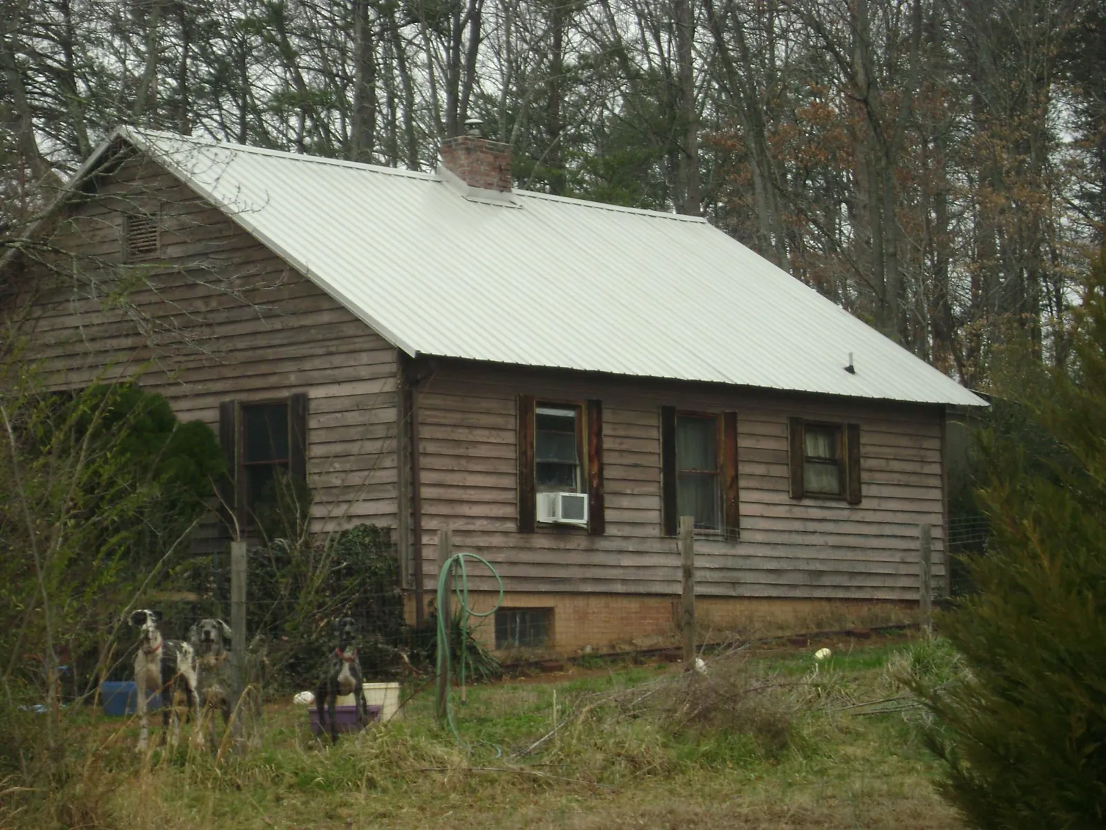 White metal roof on an old wood sided farmhouse, from a Metal Roof Installation job in Preemption